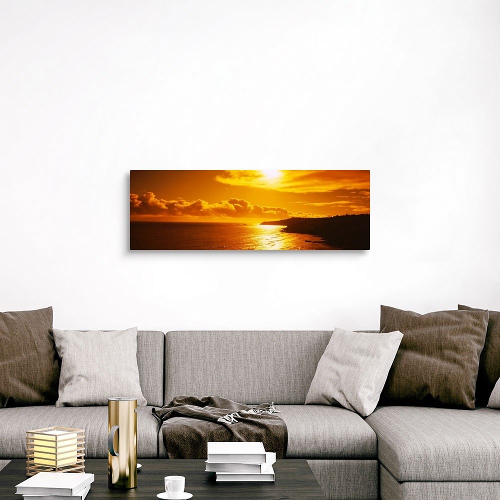 A traditional room featuring This photograph is a panoramic seascape of the sun reflecting off the shallow beach water as it s...
