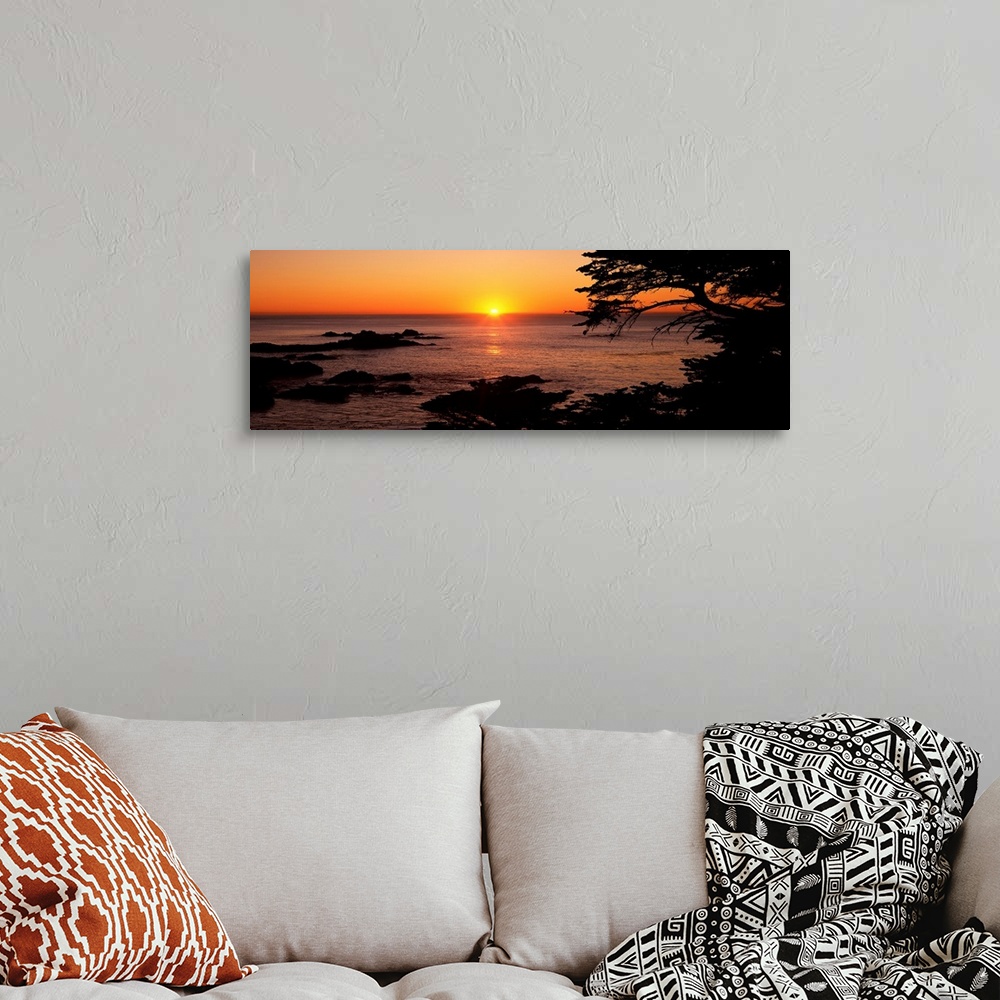 A bohemian room featuring Panoramic photograph of ocean with rocks emerging at the surface at dusk.  The sky is clear and t...