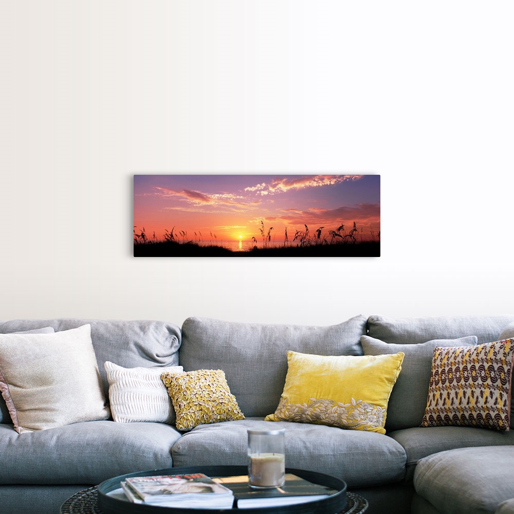 A farmhouse room featuring This wall art is a panoramic photograph of silhouetted sea grass in front of a calm sea at the en...