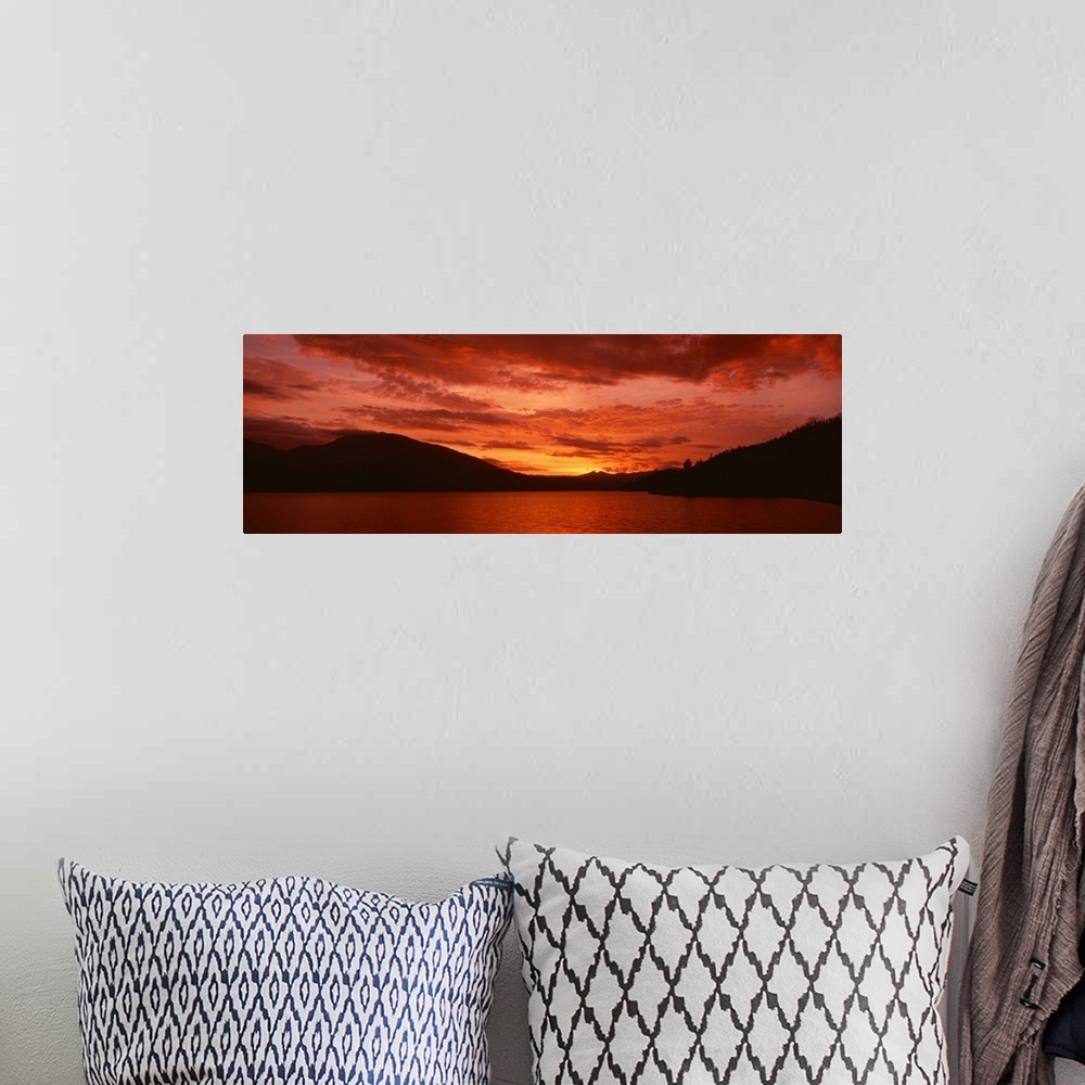 A bohemian room featuring Panoramic photograph of a vibrant fiery sunset over a silhouetted mountain landscape and Whiskeyt...