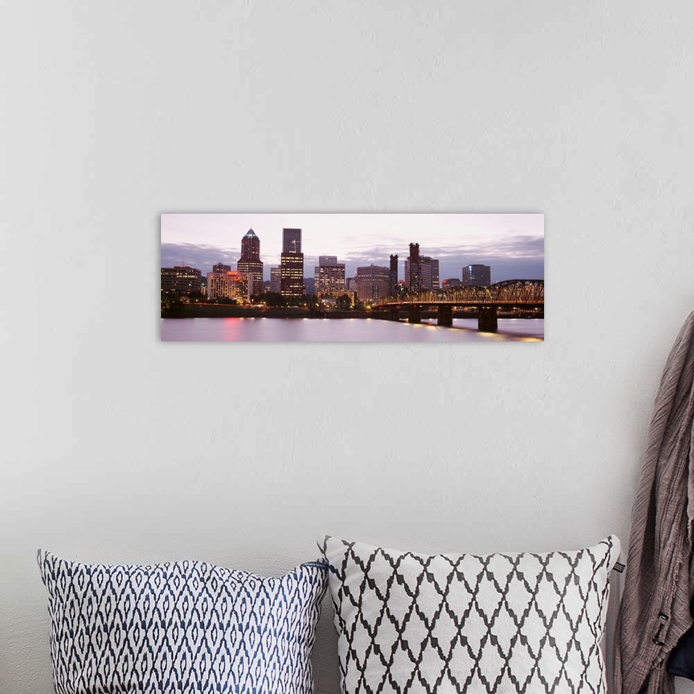 A bohemian room featuring Wide angle photograph of the Portland, Oregon skyline, lit up as the sun is setting.