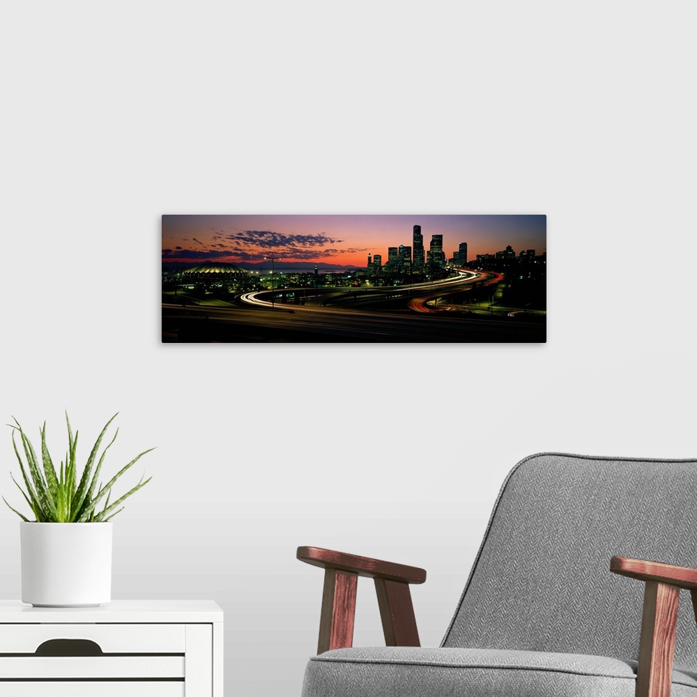 A modern room featuring Panoramic photograph emphasizes the sun as it begins to set over the busy skyline of a city in th...
