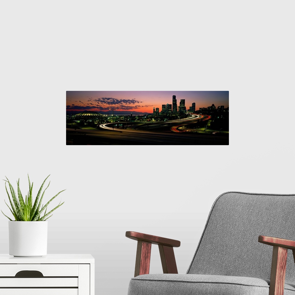 A modern room featuring Panoramic photograph emphasizes the sun as it begins to set over the busy skyline of a city in th...