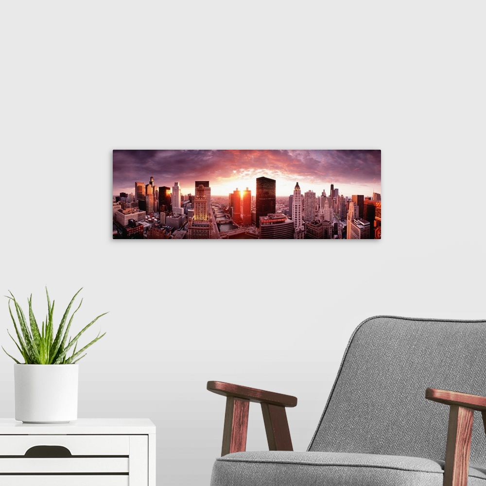 A modern room featuring This wall hanging is a panoramic photograph of the city skyline and the sun disappearing between ...