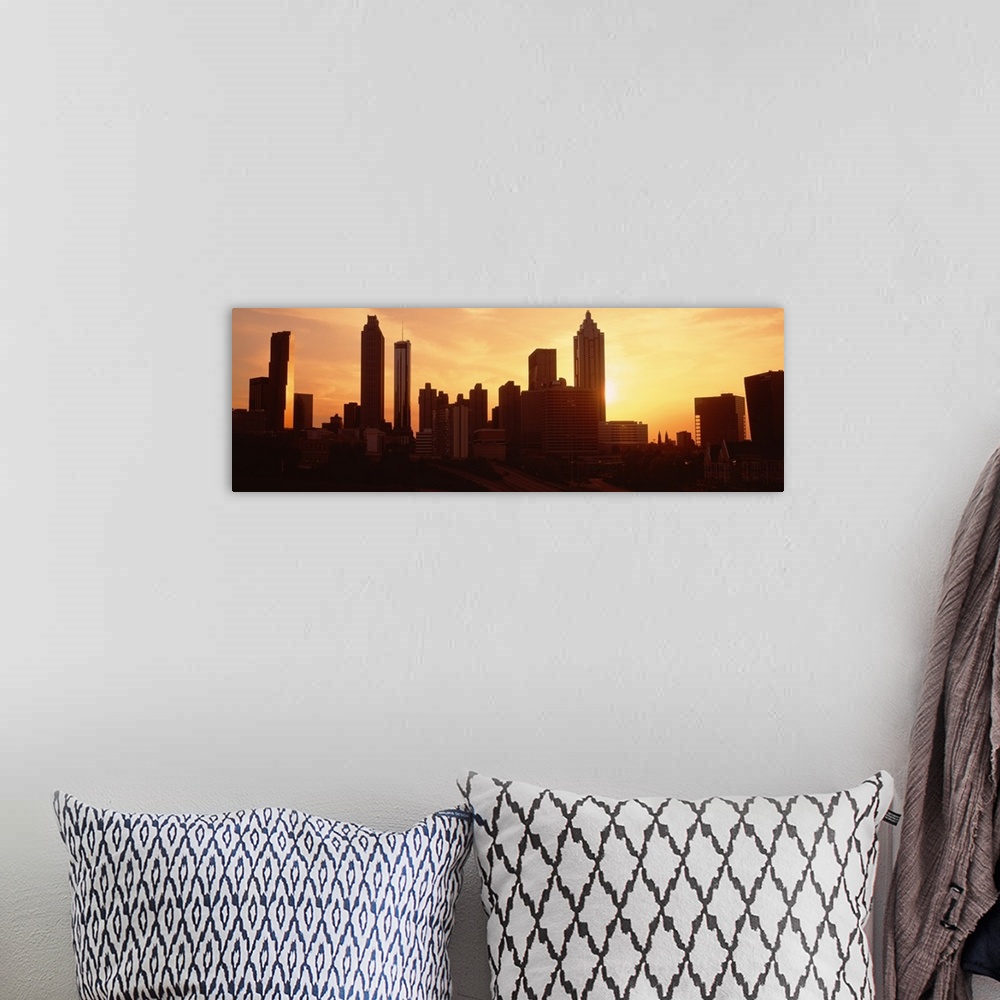 A bohemian room featuring Panoramic photograph displays the sun beginning to set over the skyline of a capital city in the ...