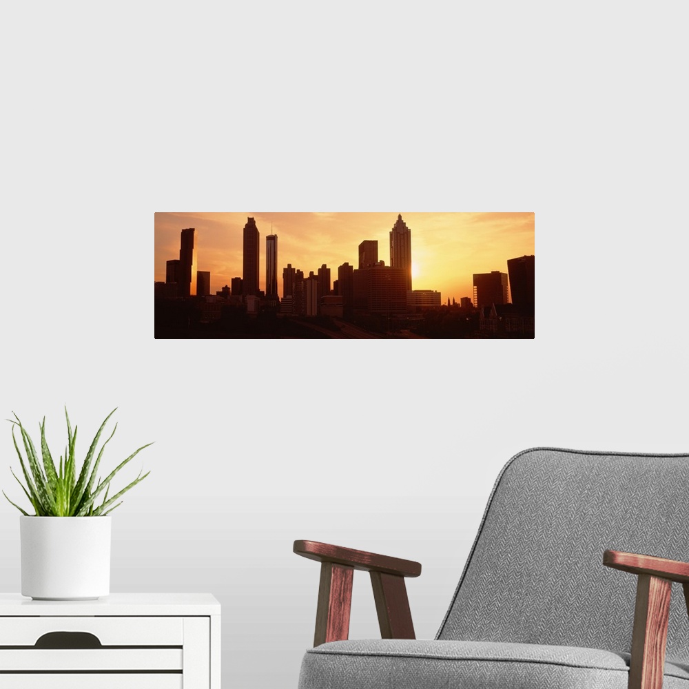 A modern room featuring Panoramic photograph displays the sun beginning to set over the skyline of a capital city in the ...