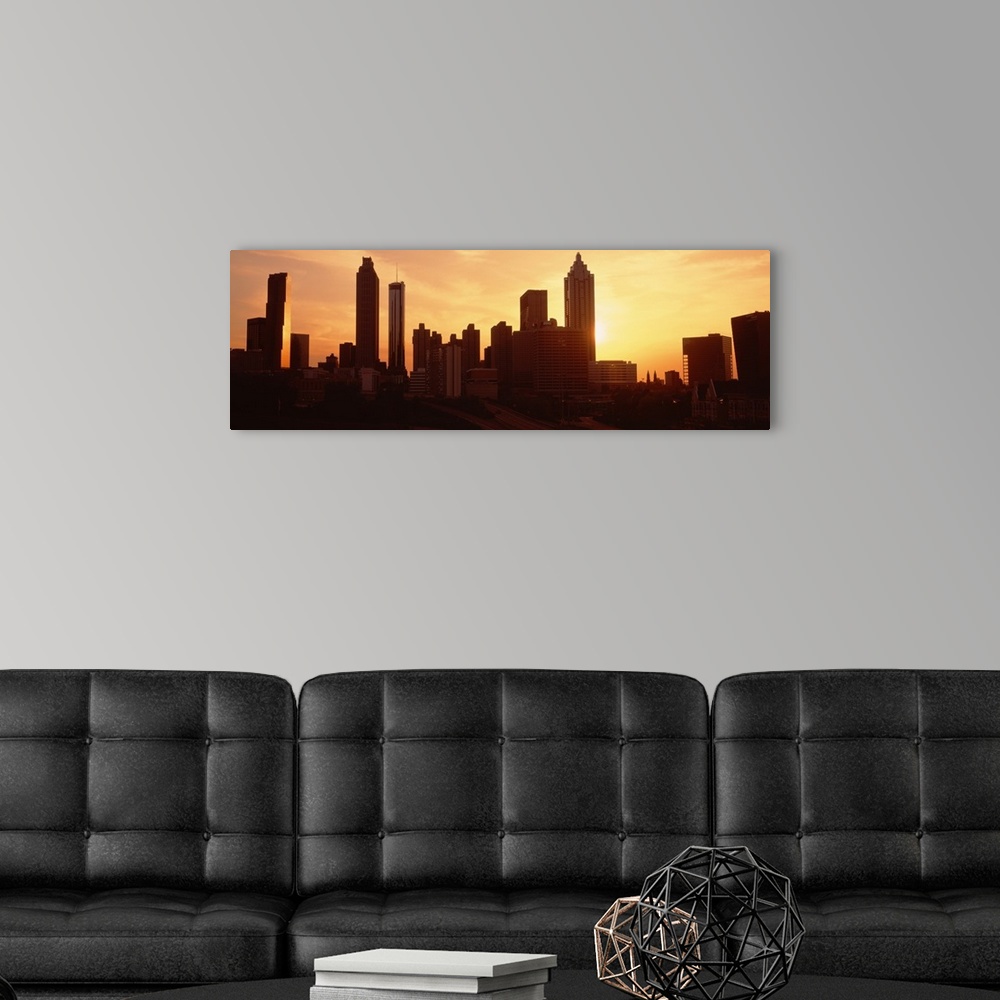 A modern room featuring Panoramic photograph displays the sun beginning to set over the skyline of a capital city in the ...