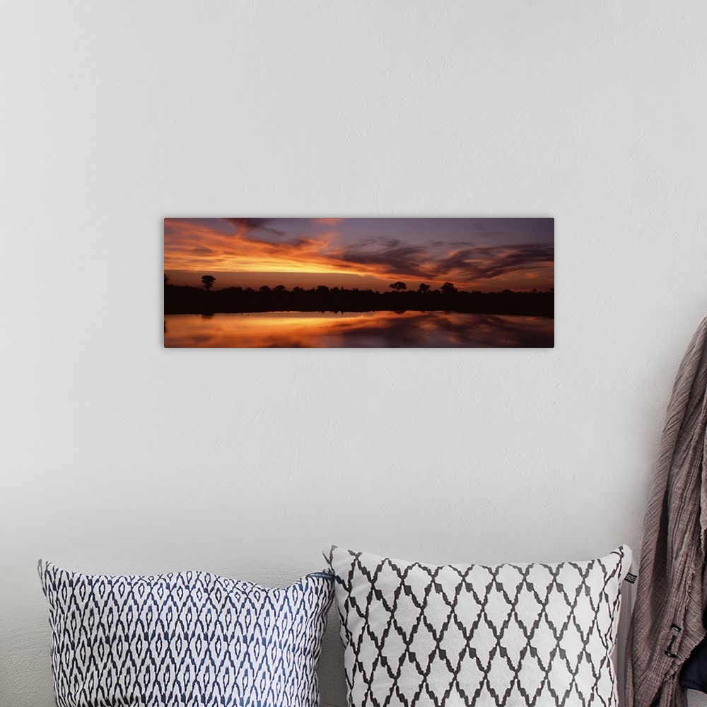 A bohemian room featuring Panoramic photo on canvas of a bright sunset along a river in Africa with a tree line silhouetted...