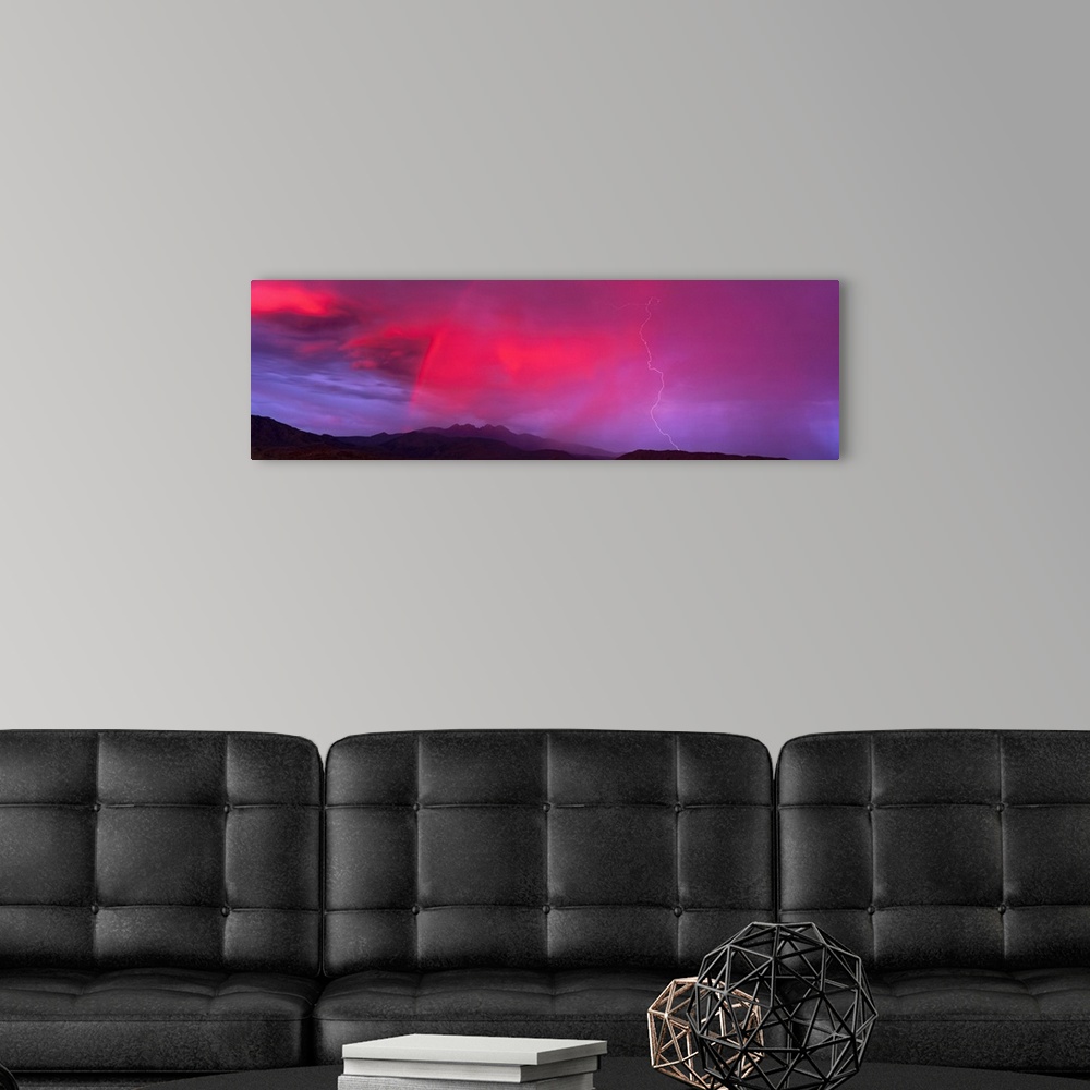 A modern room featuring This panoramic photograph is taken of a sunset sky that is highlighted with hot pink and a bolt o...