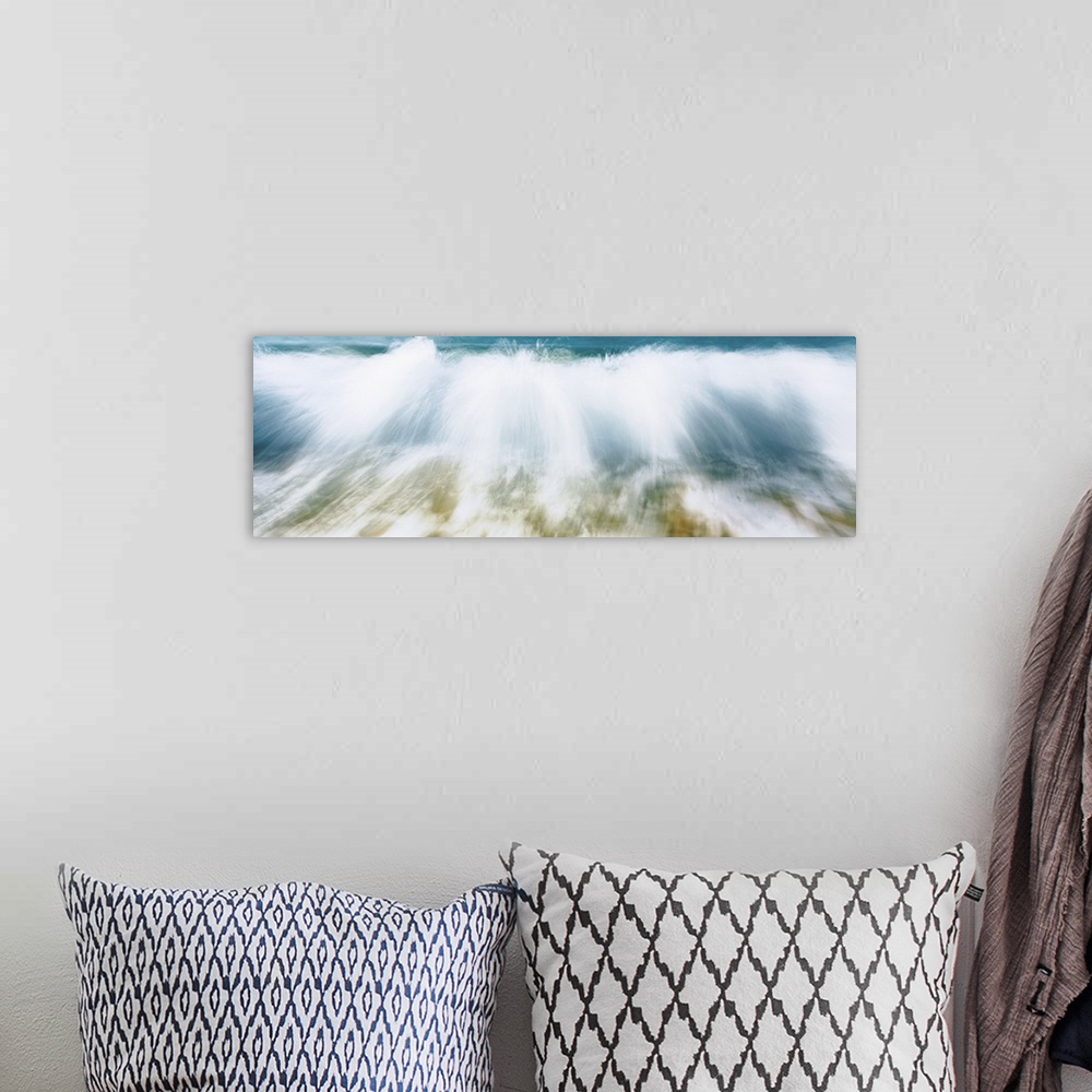 A bohemian room featuring Up-close panoramic photograph of wave crashing onto beach creating spray.