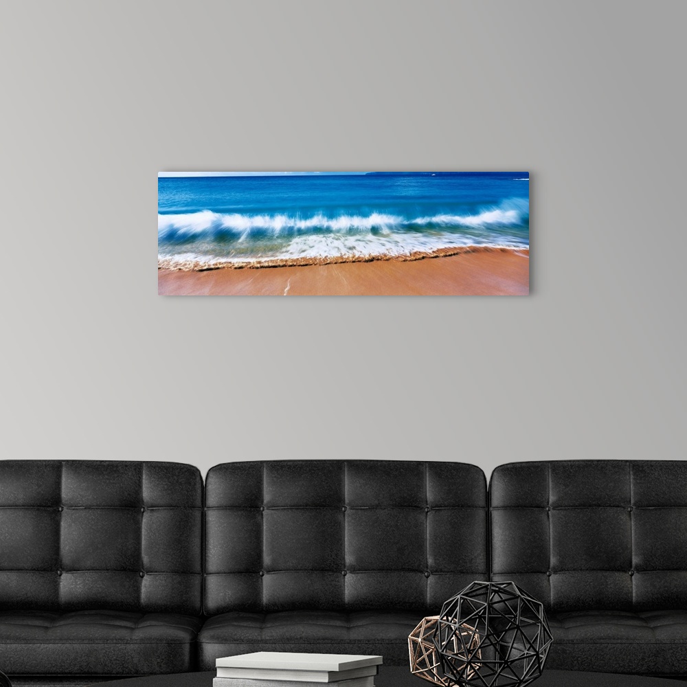 A modern room featuring Giant, landscape photograph of a large wave crashing into the sands of Big Makena Beach in Maui, ...