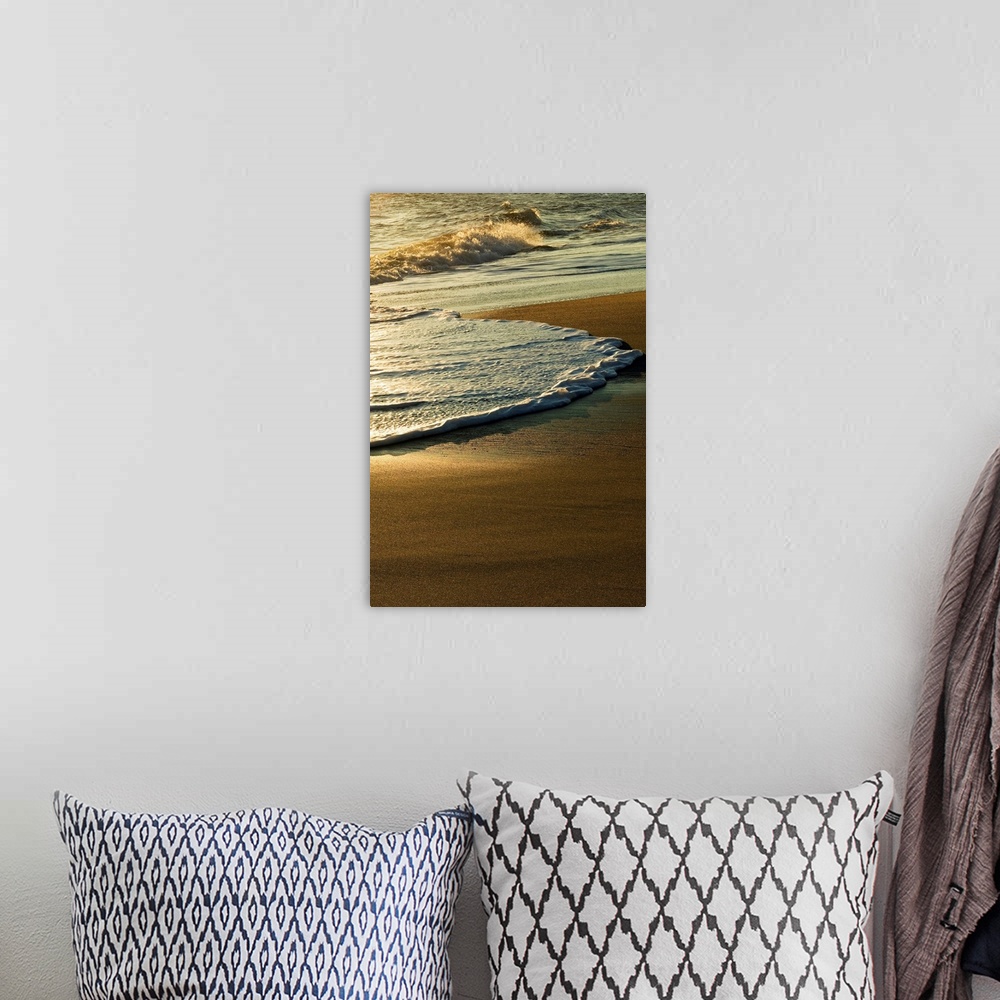 A bohemian room featuring A vertical photograph of waves washing up on the shore in the morning.