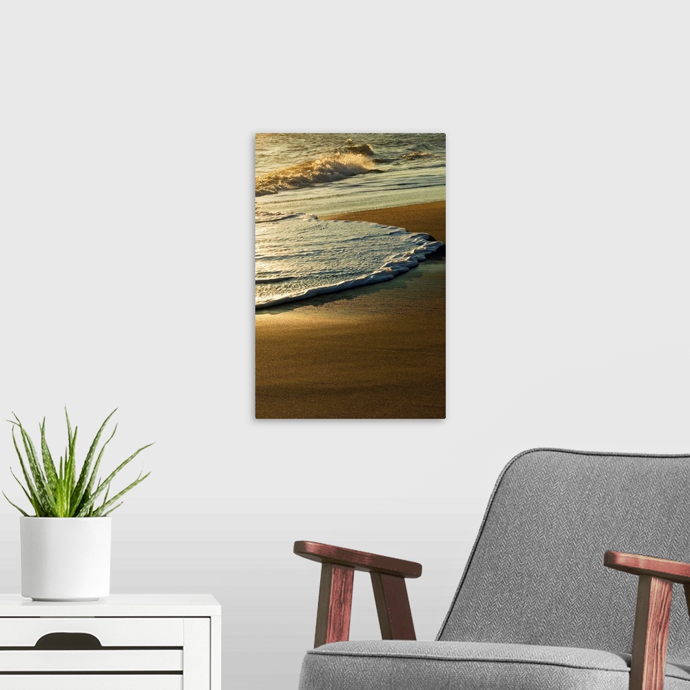 A modern room featuring A vertical photograph of waves washing up on the shore in the morning.