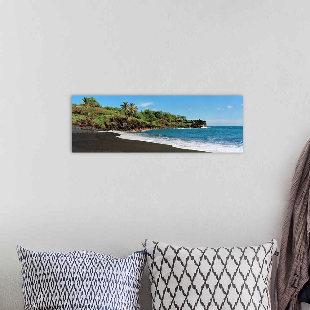 A bohemian room featuring Panoramic photograph displays the waves of the Pacific Ocean gently crashing into the sandy shore...