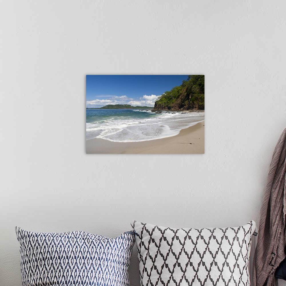 A bohemian room featuring Big photo on canvas of waves washing onto a tropical beach.