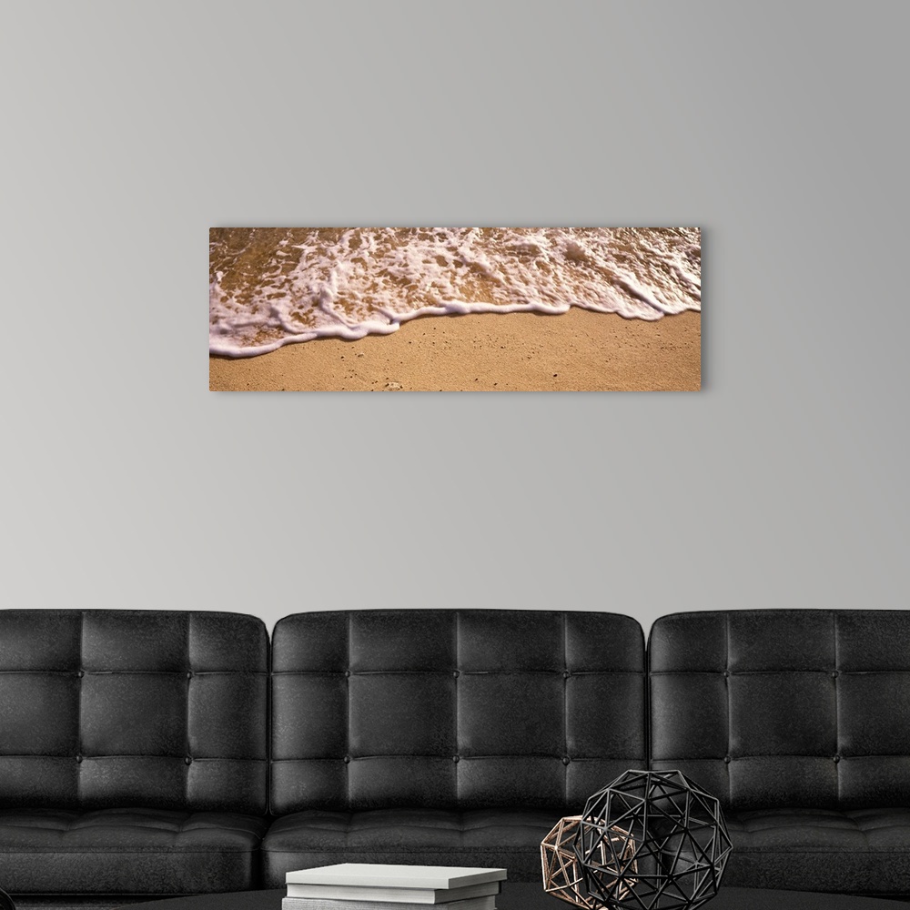 A modern room featuring Panoramic photograph of sea spray on shoreline.