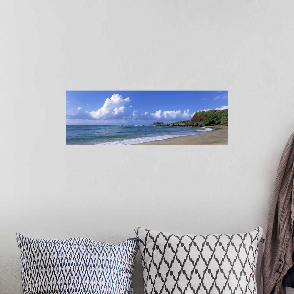 A bohemian room featuring Horizontal photograph on a giant wall hanging of the shoreline along Hamoa Beach, green hills in ...