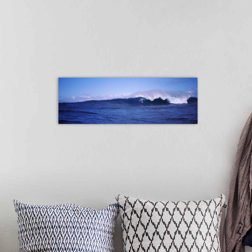 A bohemian room featuring Panoramic image of a surfer riding a large breaking wave.