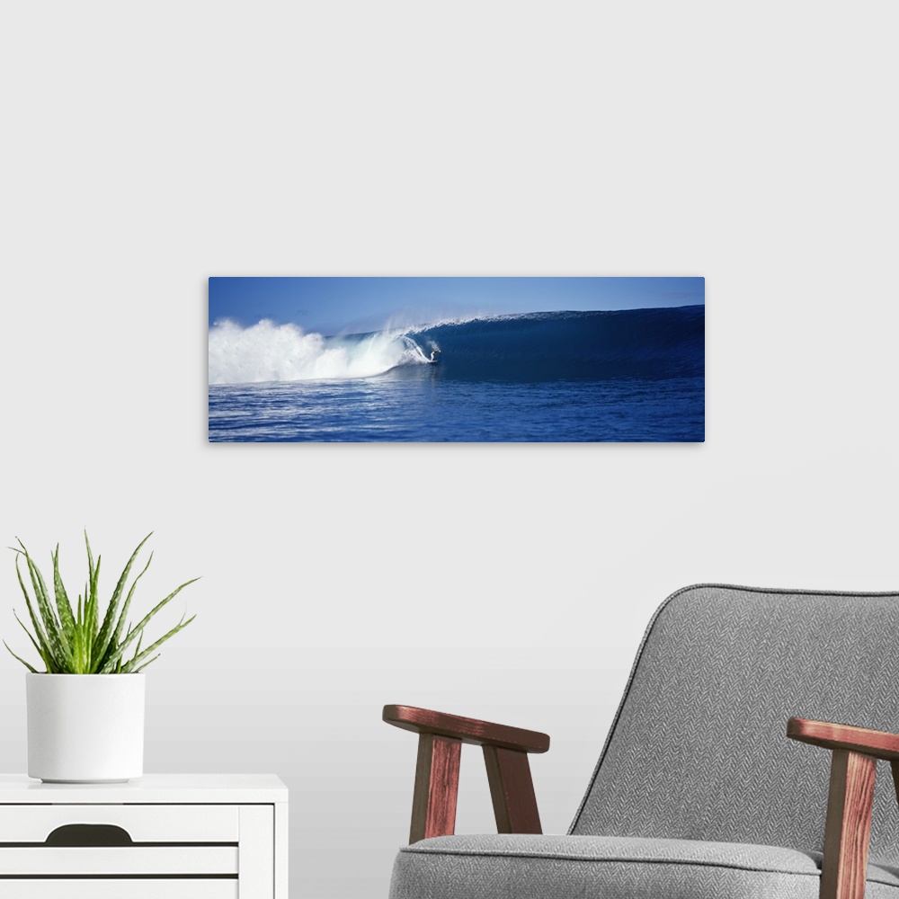 A modern room featuring A brave surfer cuts across a plunging wave as it breaks behind his board, almost enclosing him in...