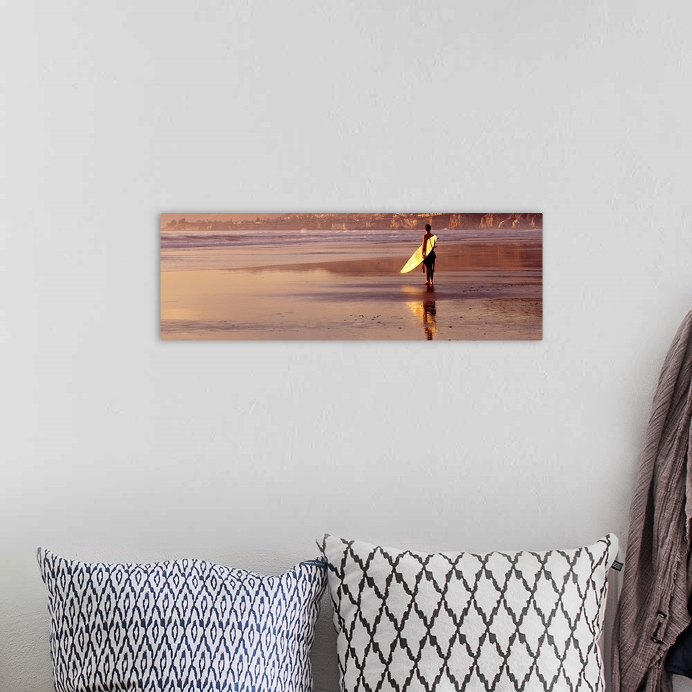 A bohemian room featuring Panoramic photograph of a single surfer walking along the shore with his surfboard at Pismo Beach...