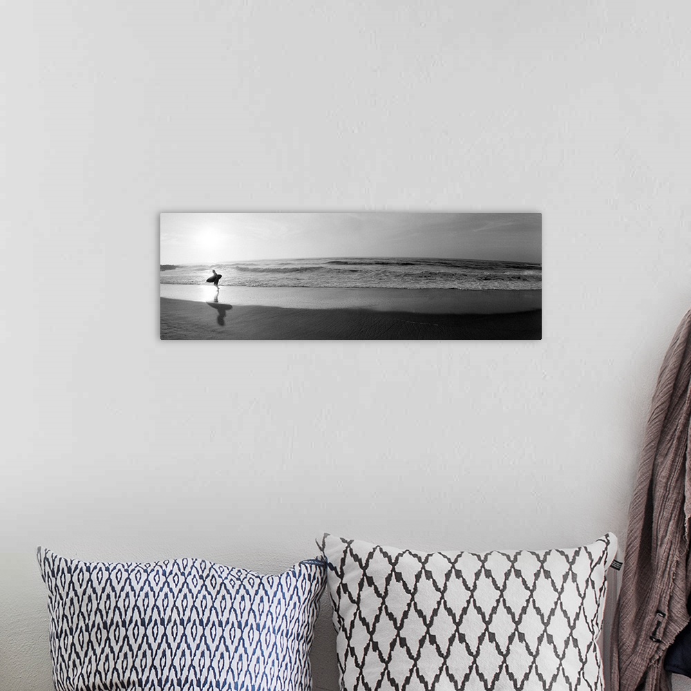 A bohemian room featuring Panoramic photograph of a surfer walking along a sandy beach in San Diego, California.  The tide ...