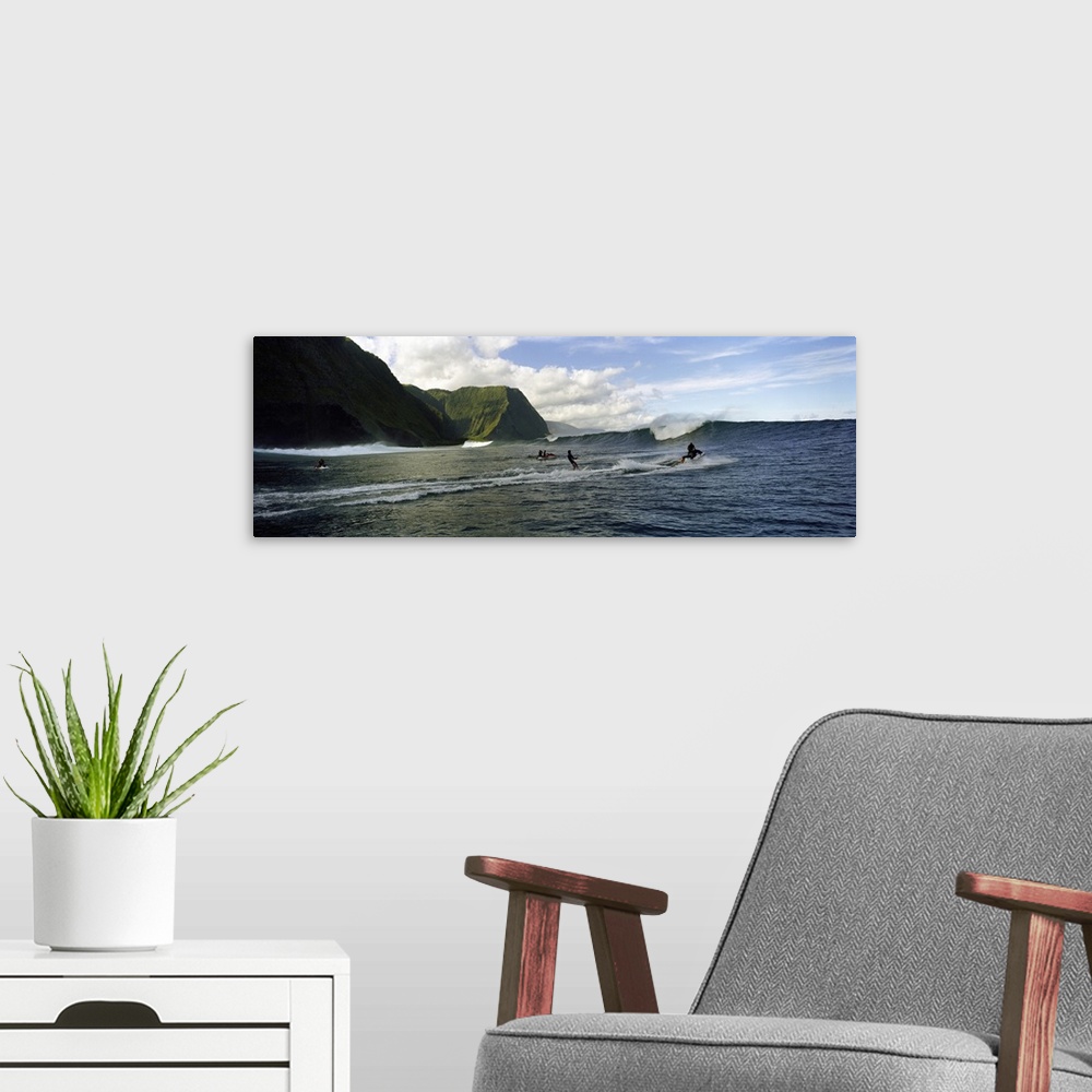 A modern room featuring This is a panoramic photograph of ocean swells and volcanic cliffs and surfers waiting to catch t...