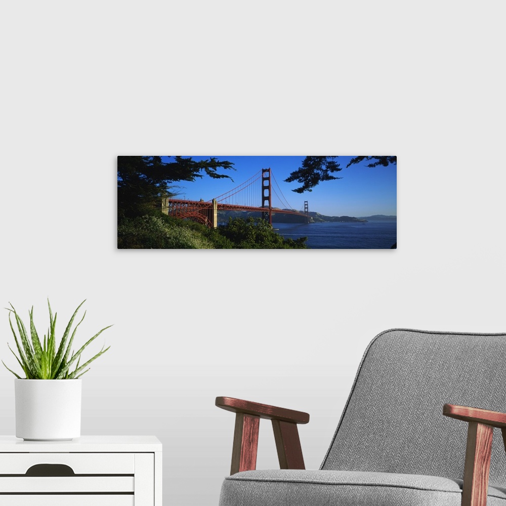 A modern room featuring Panoramic photograph on a big canvas looking over a green hillside at the Golden Gate Bridge, ext...