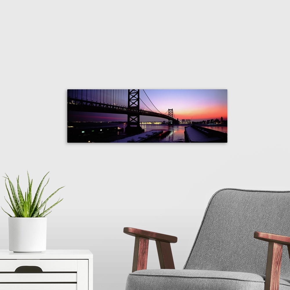 A modern room featuring Long horizontal photo print of a big bridge in Philadelphia reaching across a river at sunset.