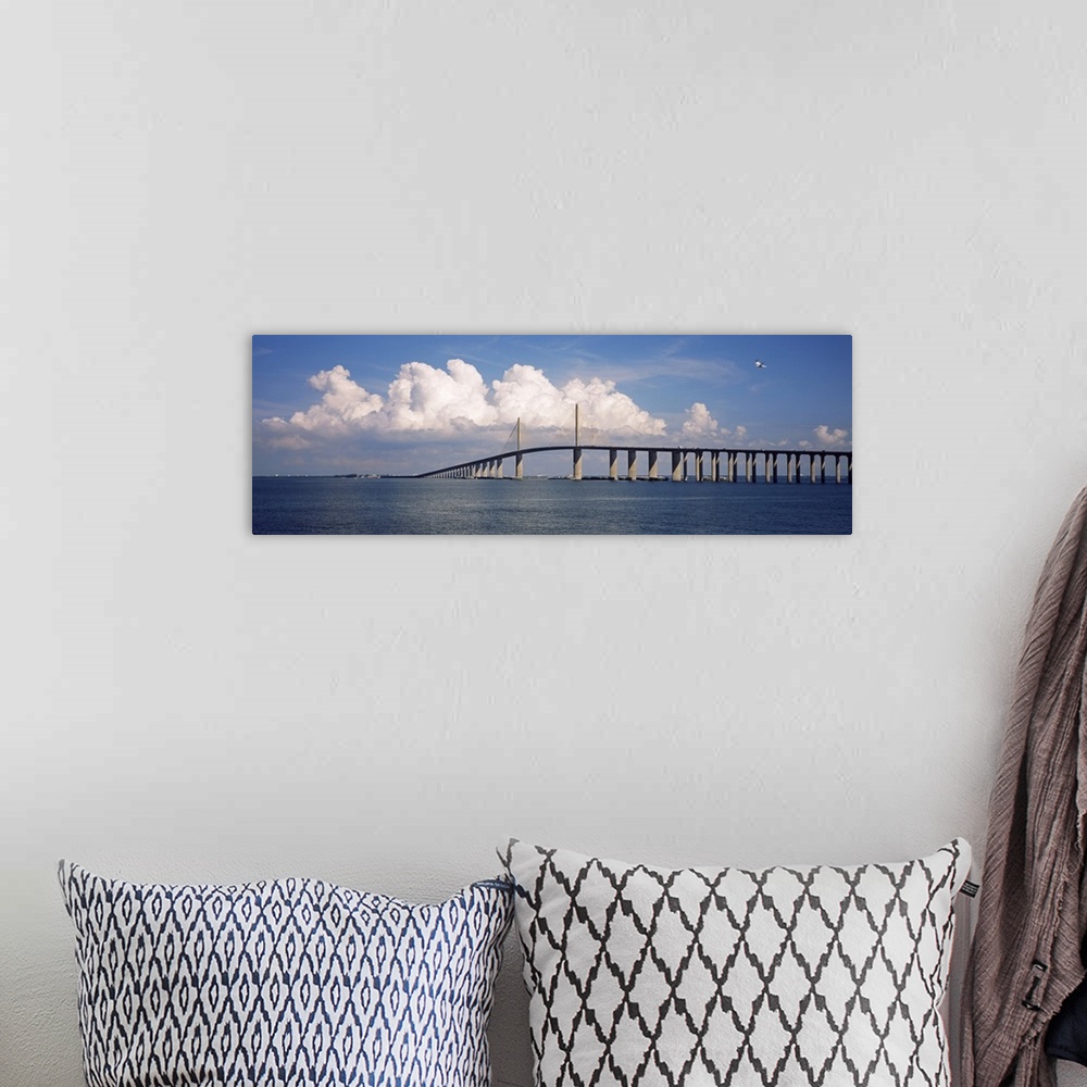 A bohemian room featuring Oversized, horizontal photograph of white fluffy clouds and a blue sky over the Sunshine Skyway B...