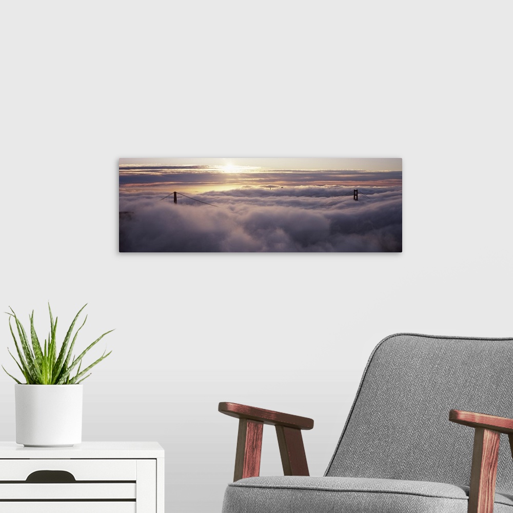 A modern room featuring Panoramic photo of the tops of the Golden Gate Bridge peeking through the dense fog.
