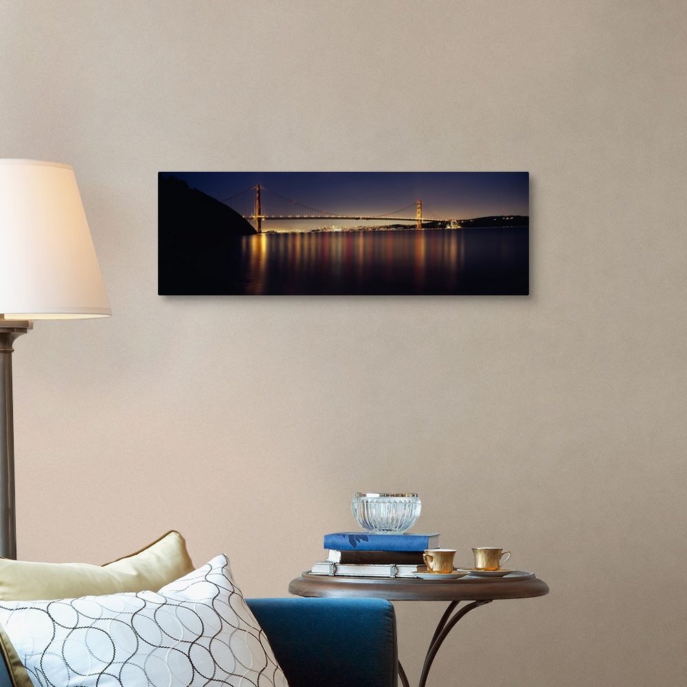 A traditional room featuring Wide angle photograph of the Golden Gate Bridge in the distance, lit at night and reflecting over...