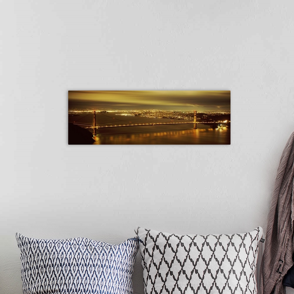 A bohemian room featuring Giant, wide angle photograph of the Golden Gate Bridge lit up at night, the city lights of San Fr...