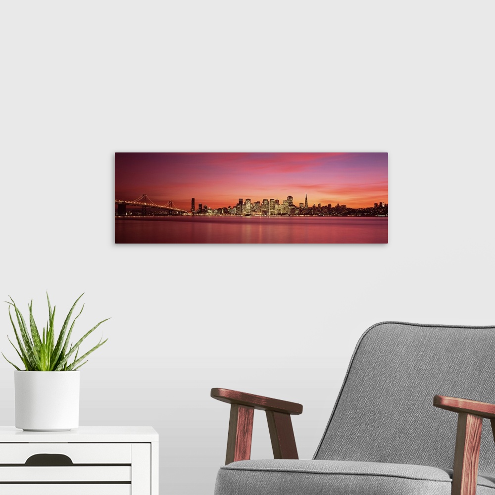 A modern room featuring Cityscape in the evening with lights on the skyscrapers as the sunlight fades away with wispy pin...