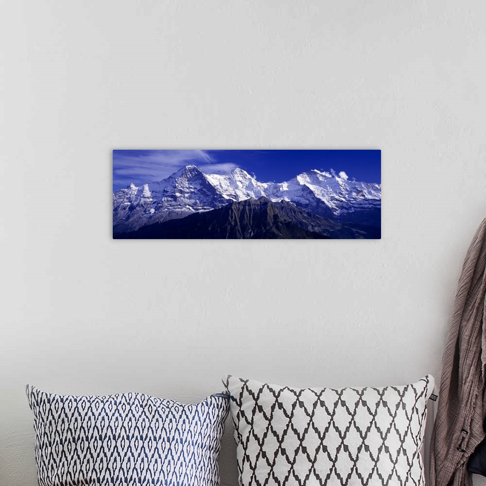 A bohemian room featuring Giant, landscape photograph of snow covered Swiss mountains against a deep blue sky in Berner, Ob...