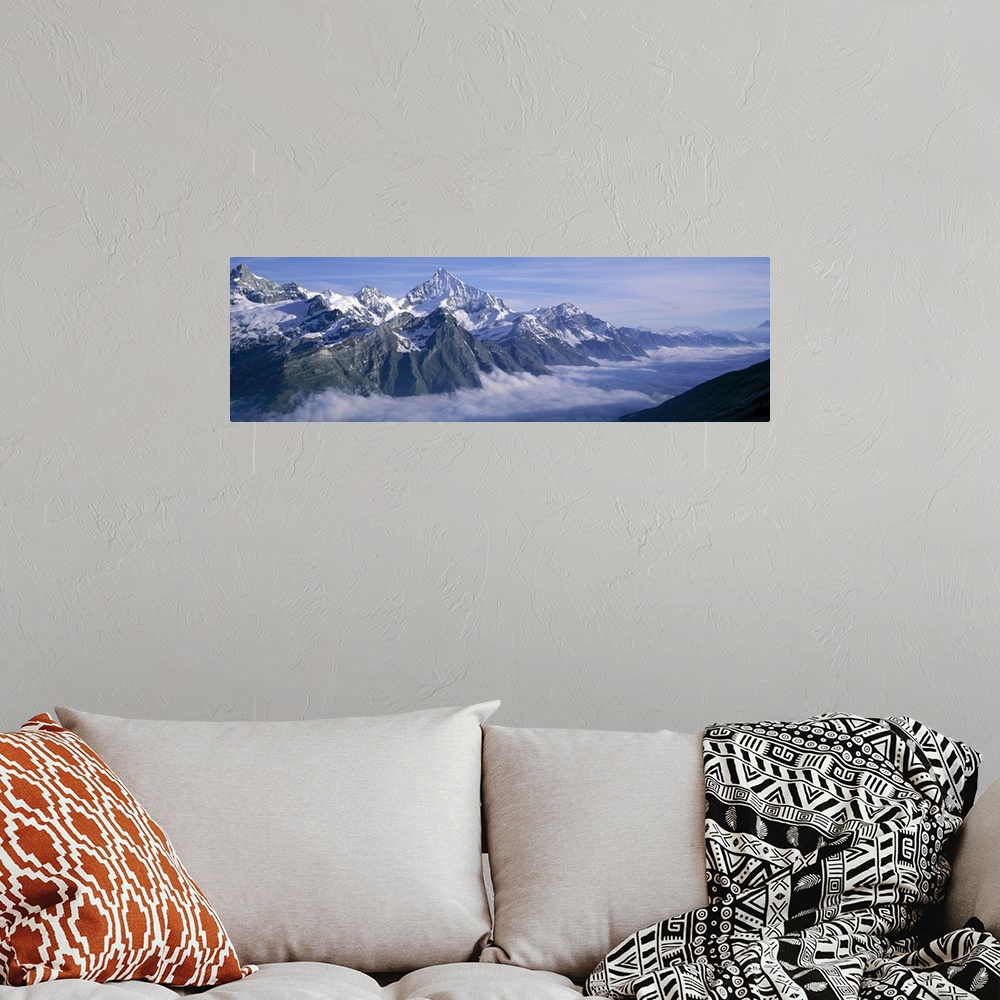A bohemian room featuring Panoramic, aerial photograph of thick clouds surrounding the snow capped Swiss Alps, against a bl...