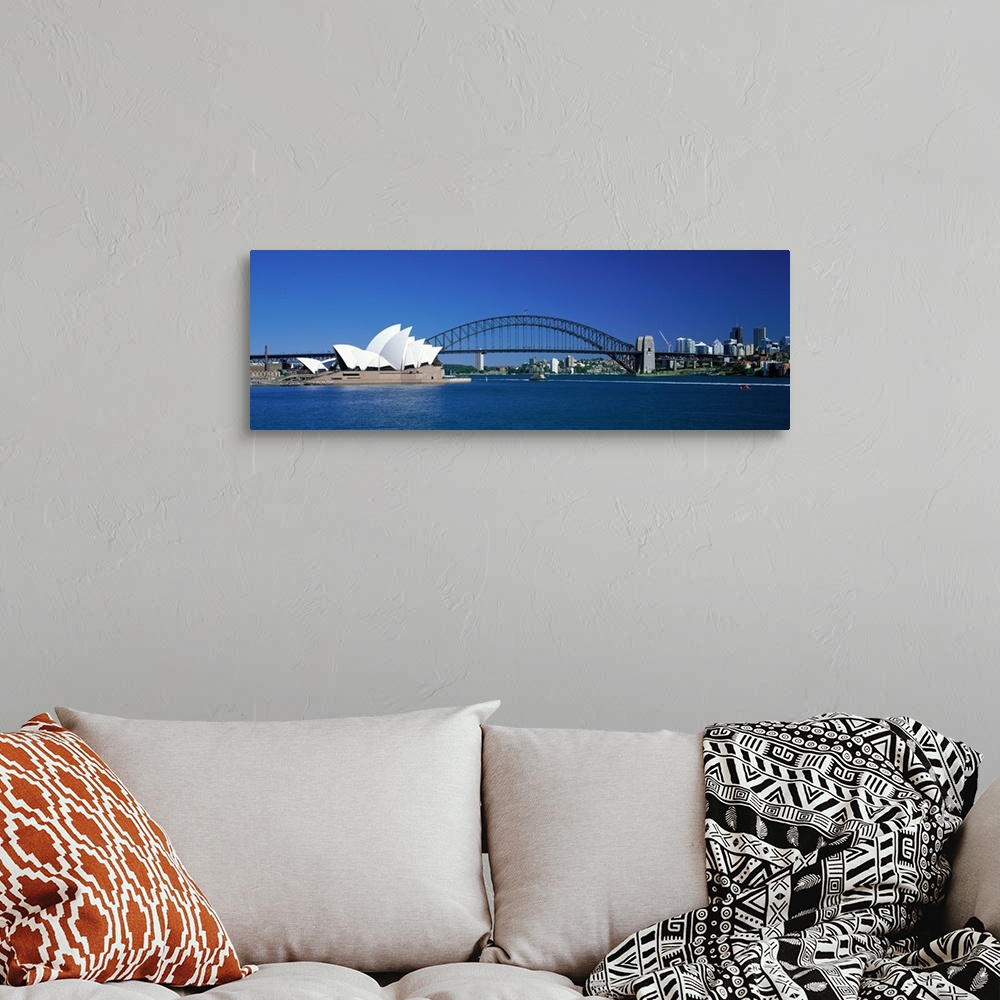 A bohemian room featuring This is a panoramic photograph of the harbor with the suspension bridge, opera house, and city sk...