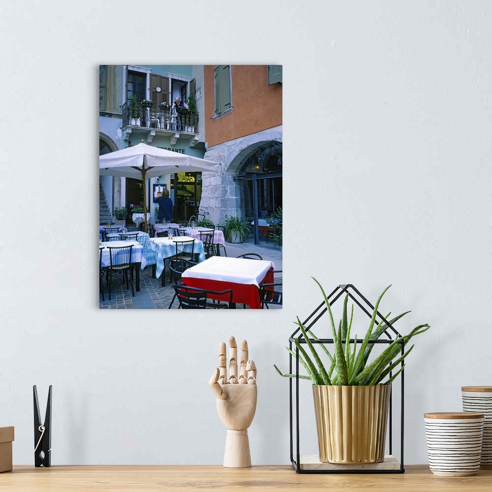A bohemian room featuring Vertical panoramic photograph outside eatery next to street shops at dusk.