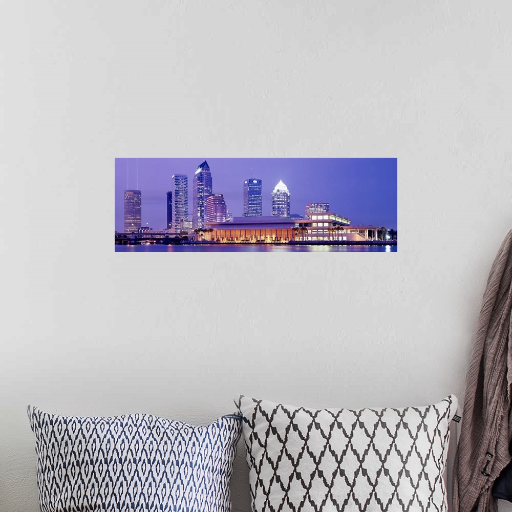 A bohemian room featuring The Tampa skyline is photographed in panoramic view during the night with the buildings all illum...