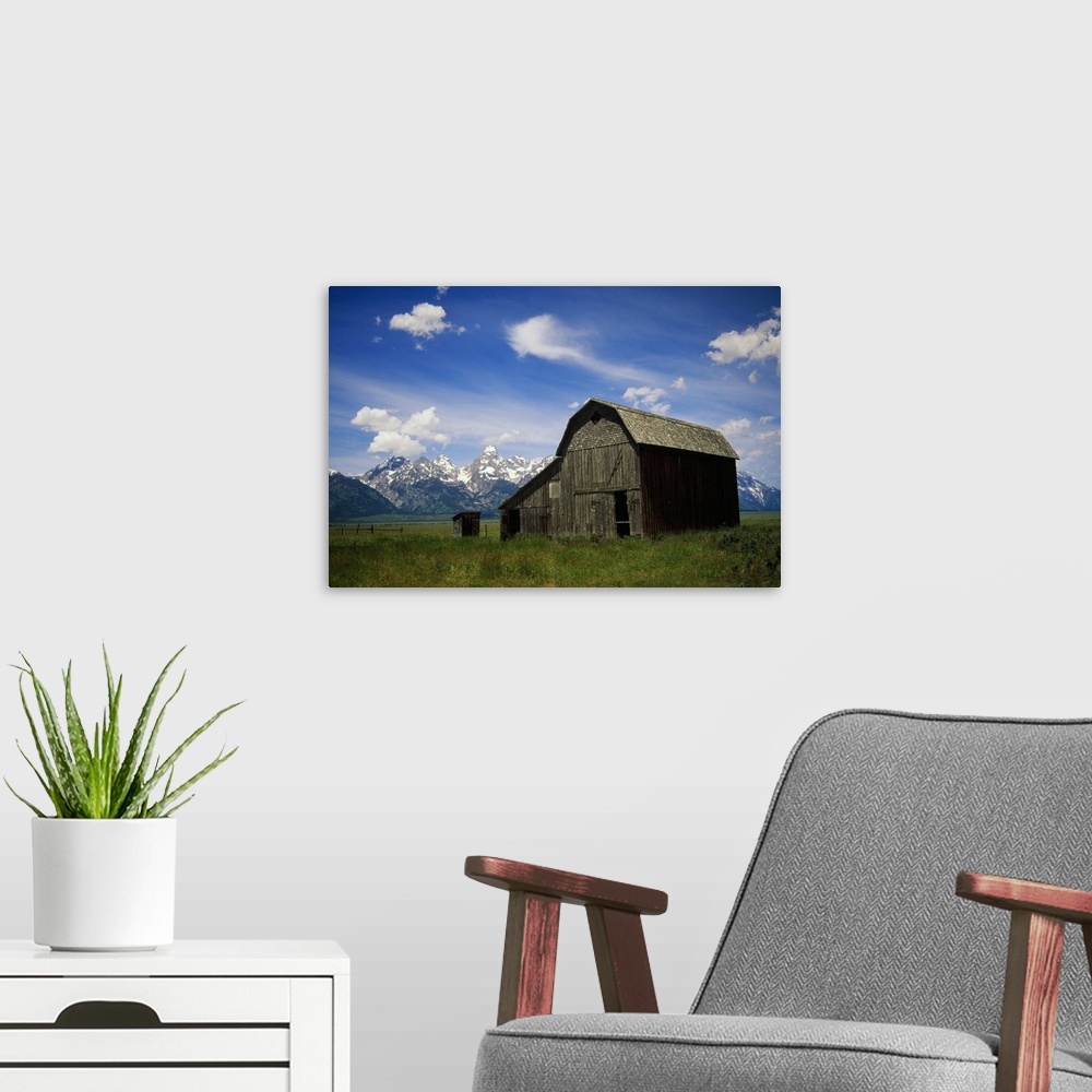 A modern room featuring Large photograph of a rustic barn in a grassy field with a mountain range behind it in Grand Teto...