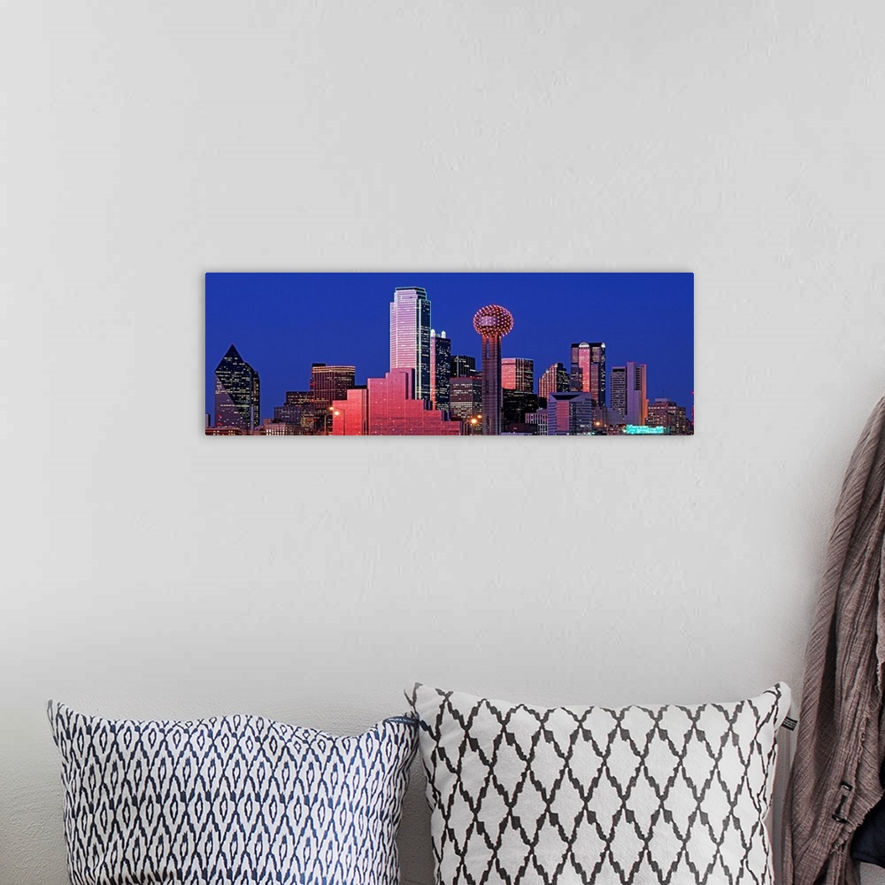 A bohemian room featuring This wall art is a panoramic photograph of the city skyline glowing and glimmering in the night sky.