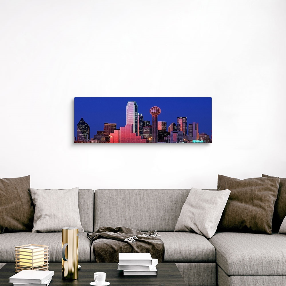 A traditional room featuring This wall art is a panoramic photograph of the city skyline glowing and glimmering in the night sky.