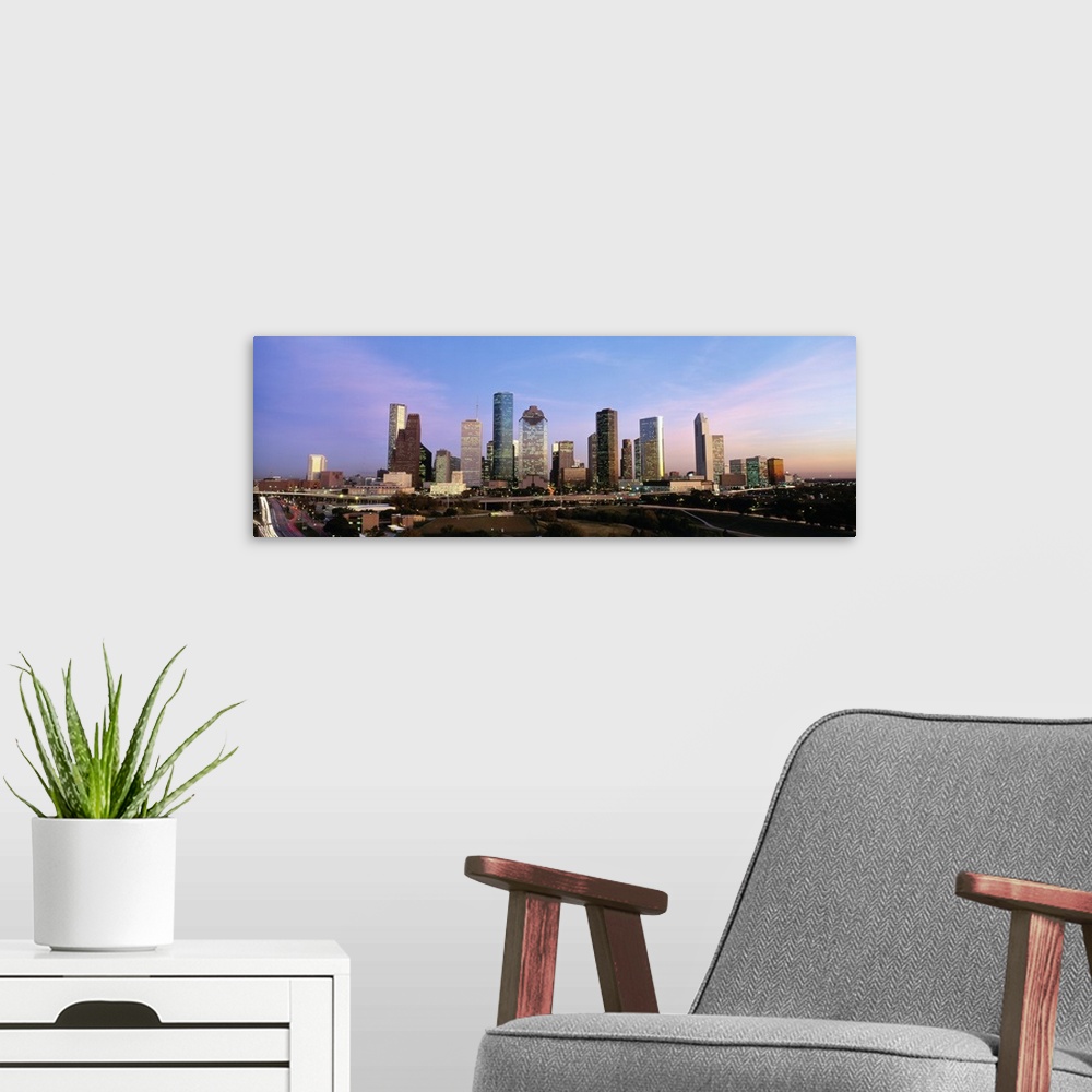 A modern room featuring Houston skyline buildings at twilight.
