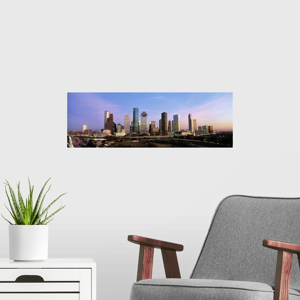 A modern room featuring Houston skyline buildings at twilight.