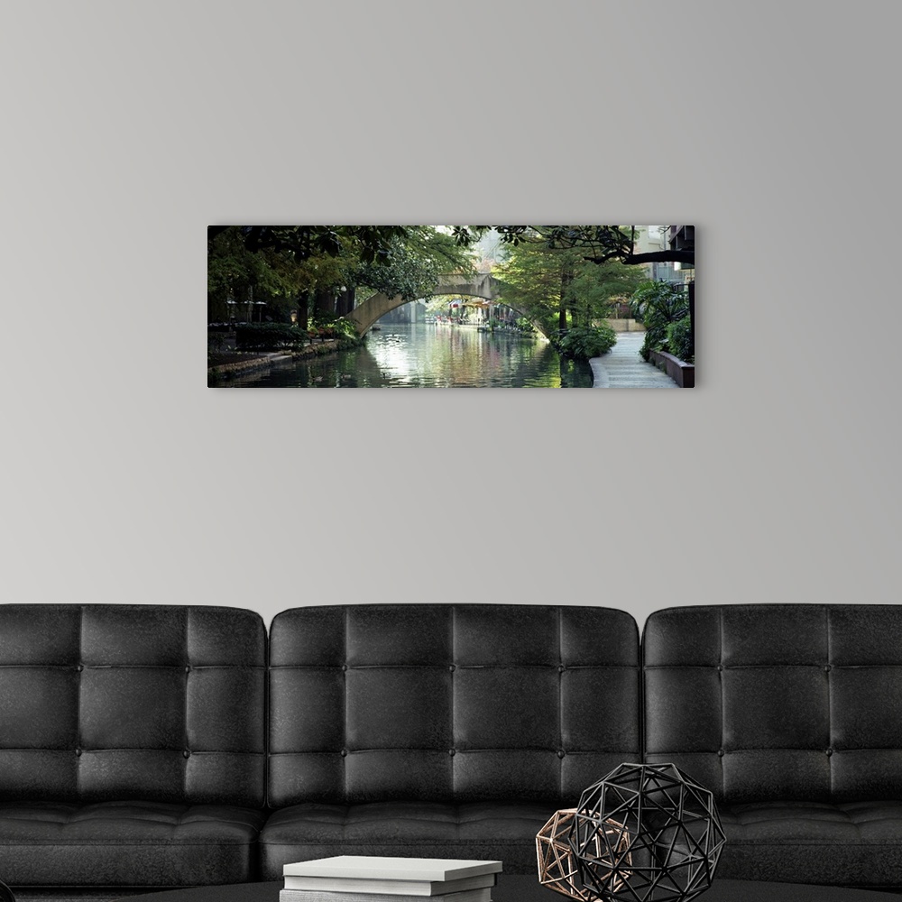 A modern room featuring Panoramic image of the canal in San Antonio with sidewalks, trees, and restaurants lining the wat...