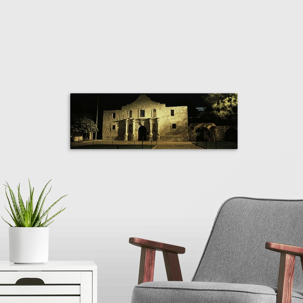 A modern room featuring Large, panoramic photograph of New Mexico's famous Alamo, shone in the light as it is surrounded ...