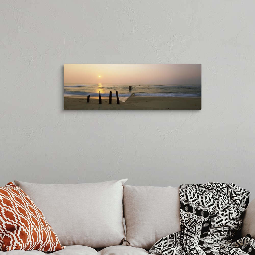 A bohemian room featuring Posts and tide break on the beach at sunrise, Cape Hatteras National Seashore, North Carolina, USA