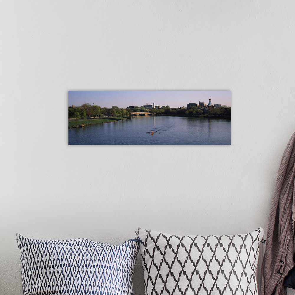 A bohemian room featuring Panoramic photograph of rower in lake lined by trees with bridge in the distance under a clear sky.