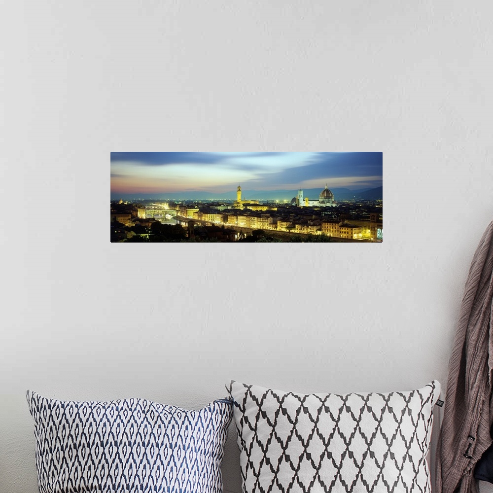 A bohemian room featuring An aerial panorama looking overtop lit up buidings in Florence, Italy as the Duomo sticks up high...