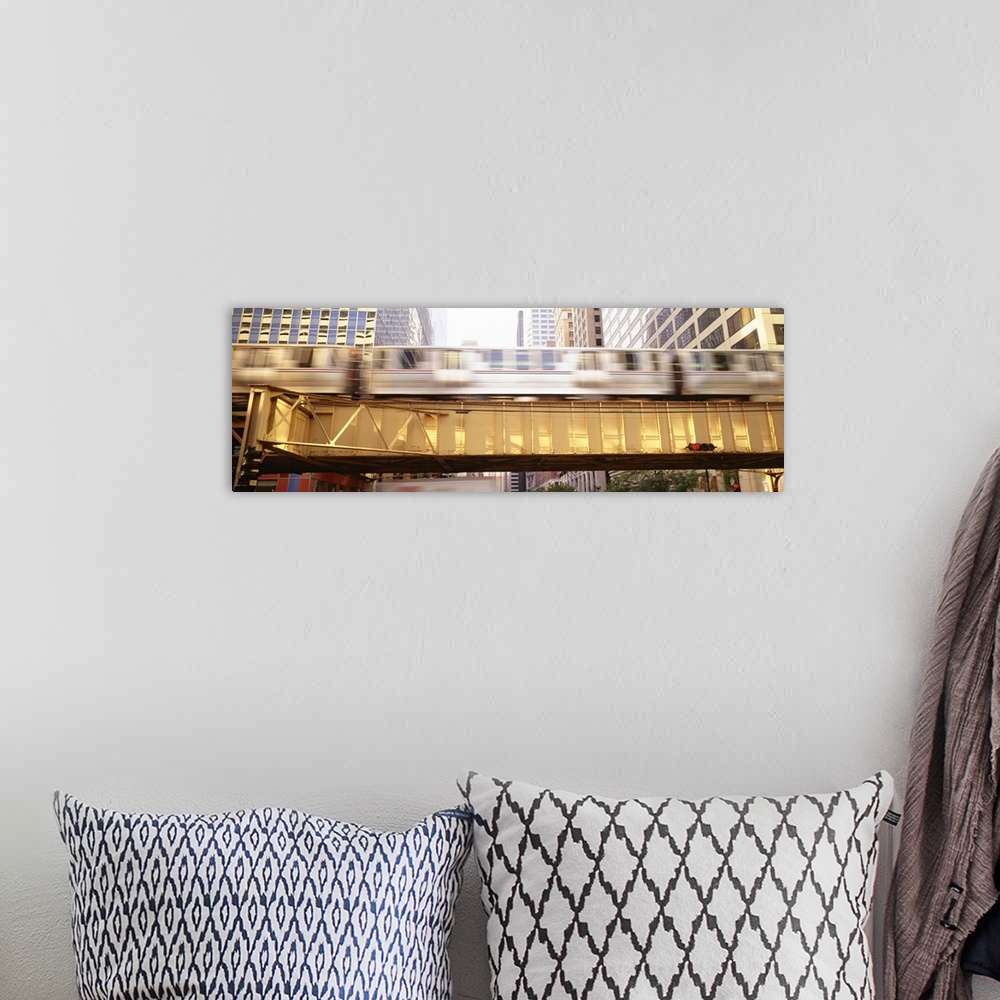 A bohemian room featuring Pamoramic style photo of a commuter train in Chicago flying by on an elevated bridge in downtown.