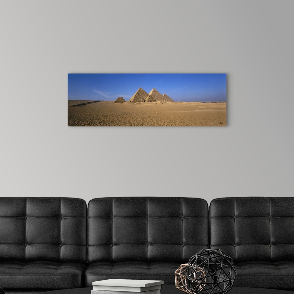 A modern room featuring The pyramids in Egypt are photographed in wide angle view from a distance with a clear blue sky b...